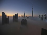 Matahari terbit di atas cakrawala kota dengan Burj Khalifa, gedung tertinggi di dunia, pada hari berkabut di Dubai, Uni Emirat Arab. (AP Photo/Kamran Jebreili/File Foto)