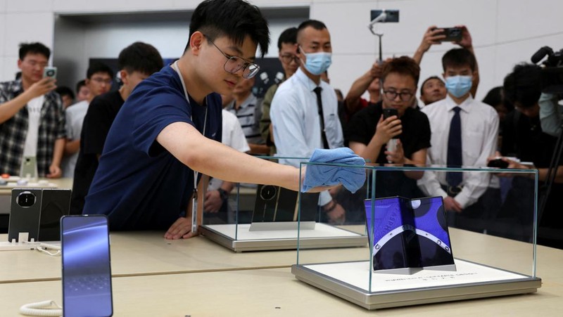 Seorang anggota staf bersiap untuk memamerkan Huawei Mate XT, telepon pintar yang dapat dilipat tiga, di toko utama Huawei di Beijing, Cina, 10 September 2024. (REUTERS/Florence Lo)