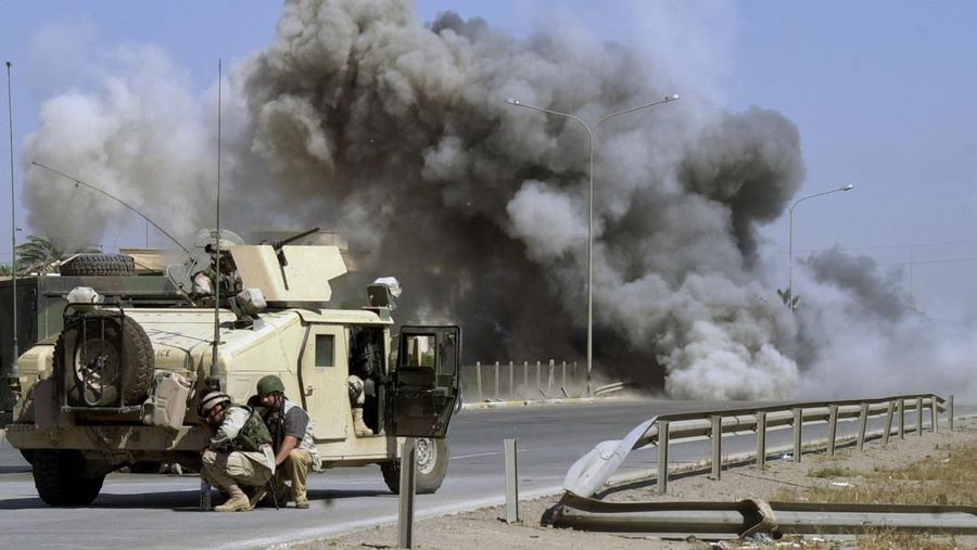 Tentara AS berlindung saat meledakkan ranjau yang ditemukan beberapa saat sebelumnya di jalan raya menuju bandara Baghdad, Irak, Senin, 26 April 2004. (AP Photo/Khalid Mohammed)