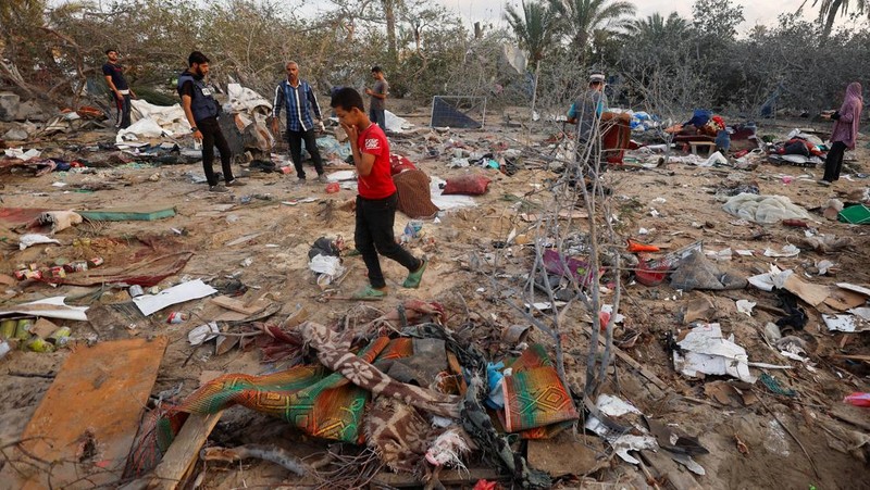 Orang-orang memeriksa lokasi setelah serangan Israel terhadap kamp tenda yang melindungi orang-orang terlantar, di tengah konflik Israel-Hamas, di daerah Al-Mawasi di Khan Younis, di Jalur Gaza selatan, 10 September 2024. (REUTERS/Mohammed Salem)