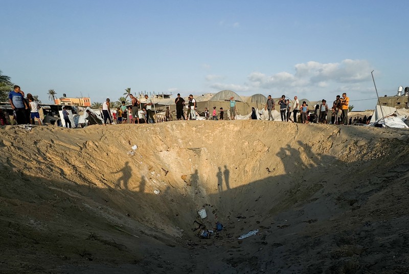 Orang-orang memeriksa lokasi setelah serangan Israel terhadap kamp tenda yang melindungi orang-orang terlantar, di tengah konflik Israel-Hamas, di daerah Al-Mawasi di Khan Younis, di Jalur Gaza selatan, 10 September 2024. Orang-orang memeriksa lokasi setelah serangan Israel terhadap kamp tenda yang melindungi orang-orang terlantar, di tengah konflik Israel-Hamas, di daerah Al-Mawasi di Khan Younis, di Jalur Gaza selatan, 10 September 2024. (REUTERS/Mohammed Salem)