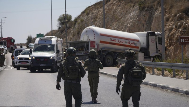 Petugas keamanan dan tanggap darurat Israel bekerja pada lokasi serangan serudukan truk bahan bakar di dekat pemukiman Givat Assaf, dekat Ramallah di Tepi Barat yang diduduki Israel, Rabu (11/9/2024). (REUTERS/Ammar Awad)