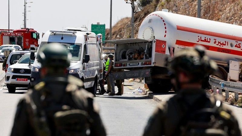 Petugas keamanan dan tanggap darurat Israel bekerja pada lokasi serangan serudukan truk bahan bakar di dekat pemukiman Givat Assaf, dekat Ramallah di Tepi Barat yang diduduki Israel, Rabu (11/9/2024). (REUTERS/Ammar Awad)