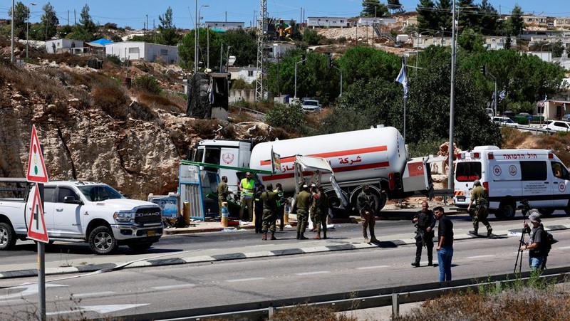 Petugas keamanan dan tanggap darurat Israel bekerja pada lokasi serangan serudukan truk bahan bakar di dekat pemukiman Givat Assaf, dekat Ramallah di Tepi Barat yang diduduki Israel, Rabu (11/9/2024). (REUTERS/Ammar Awad)