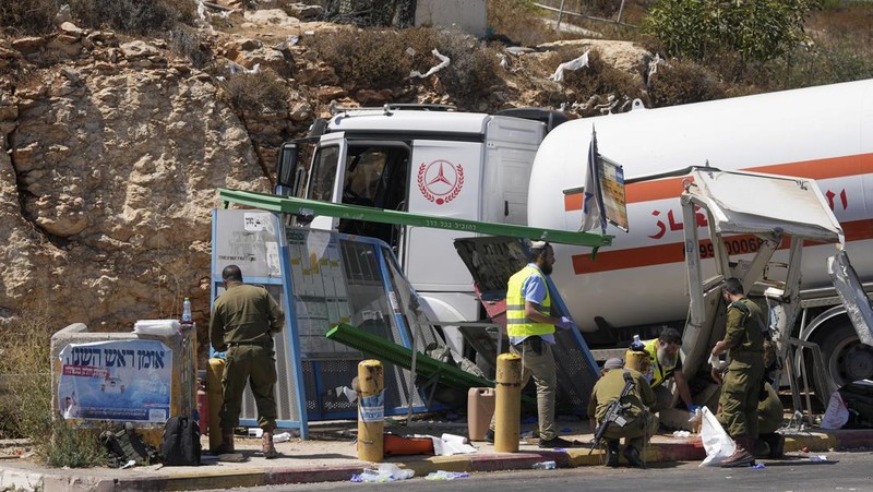 Petugas keamanan dan tanggap darurat Israel bekerja pada lokasi serangan serudukan truk bahan bakar di dekat pemukiman Givat Assaf, dekat Ramallah di Tepi Barat yang diduduki Israel, Rabu (11/9/2024). (REUTERS/Ammar Awad)