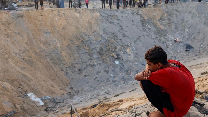 Orang-orang memeriksa lokasi setelah serangan Israel terhadap kamp tenda yang melindungi orang-orang terlantar, di tengah konflik Israel-Hamas, di daerah Al-Mawasi di Khan Younis, di Jalur Gaza selatan, 10 September 2024. (REUTERS/Mohammed Salem)