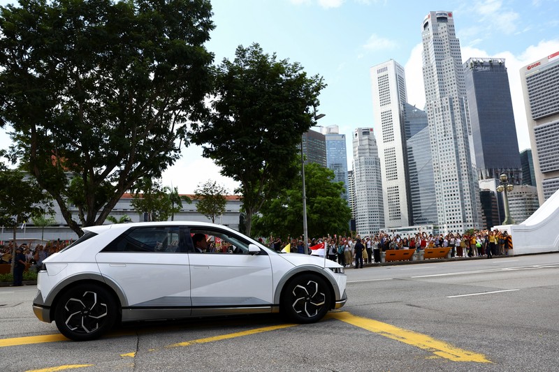 Paus Fransiskus melambaikan tangan dari mobil di Gedung Parlemen di Singapura, 12 September 2024. (REUTERS/Edgar Su)