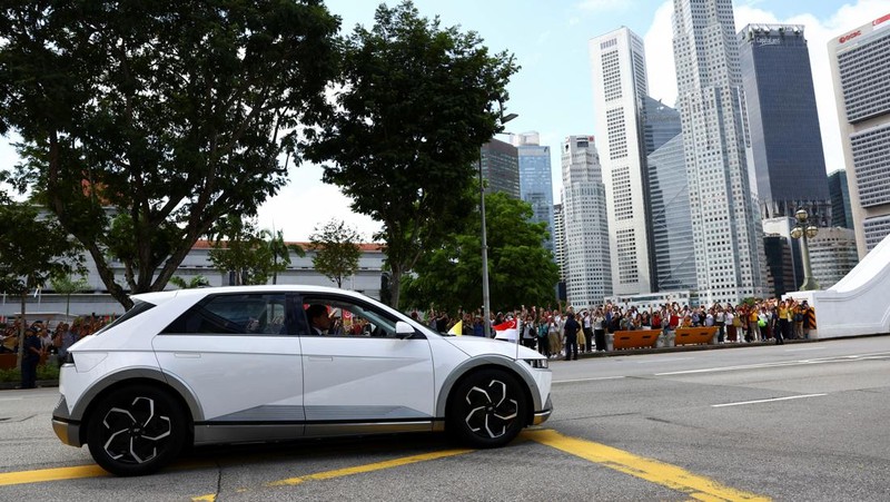 Paus Fransiskus melambaikan tangan dari mobil di Gedung Parlemen di Singapura, 12 September 2024. (REUTERS/Edgar Su)