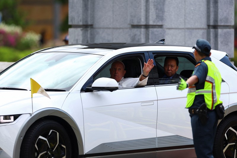 Paus Fransiskus melambaikan tangan dari mobil di Gedung Parlemen di Singapura, 12 September 2024. (REUTERS/Edgar Su)