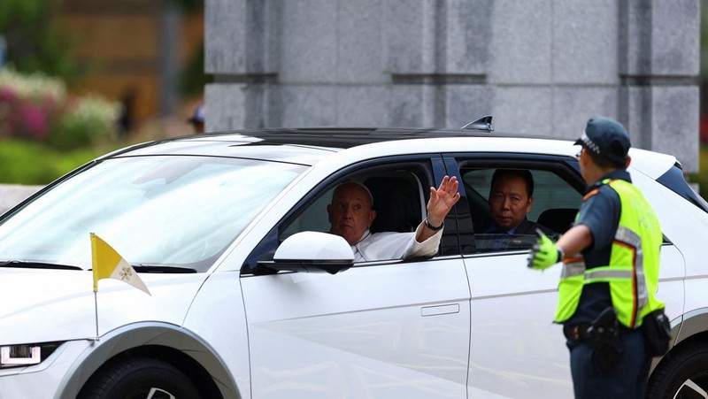 Paus Fransiskus melambaikan tangan dari mobil di Gedung Parlemen di Singapura, 12 September 2024. (REUTERS/Edgar Su)