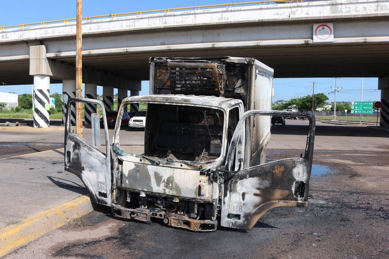 Sebuah kendaraan yang terbakar terlihat di dekat jembatan layang di tengah gelombang kekerasan antara kelompok bersenjata, di Culiacan, Meksiko, 11 September 2024. (REUTERS/Jesus Bustamante) Sebuah kendaraan yang terbakar terlihat di dekat jembatan layang di tengah gelombang kekerasan antara kelompok bersenjata, di Culiacan, Meksiko, 11 September 2024. (REUTERS/Jesus Bustamante)