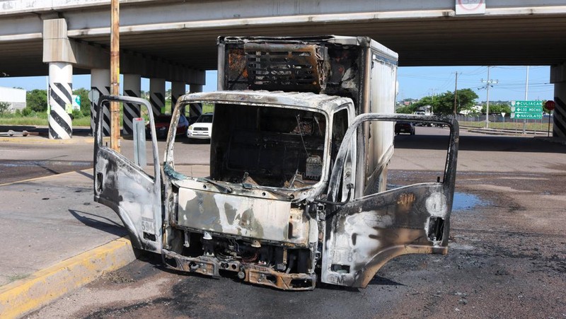 Sebuah kendaraan yang terbakar terlihat di dekat jembatan layang di tengah gelombang kekerasan antara kelompok bersenjata, di Culiacan, Meksiko, 11 September 2024. (REUTERS/Jesus Bustamante)