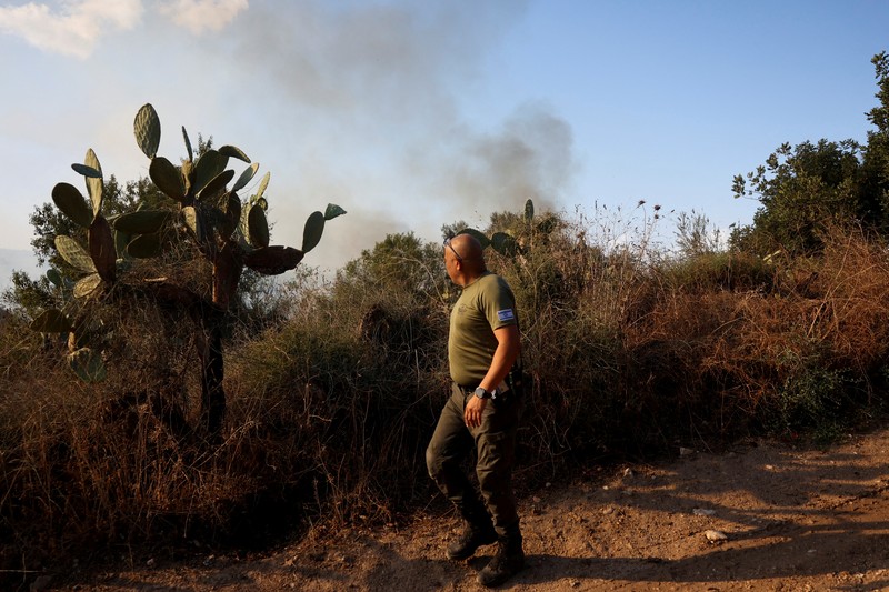 Seorang polisi memeriksa area kebakaran setelah militer menembakkan pencegat ke rudal dari Yaman yang jatuh di Israel tengah pada 15 September 2024. (REUTERS/Ronen Zvulun)