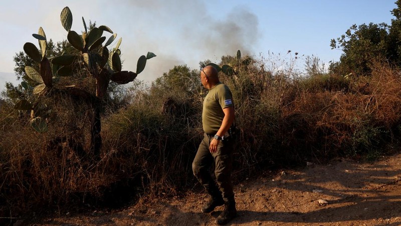 Seorang polisi memeriksa area kebakaran setelah militer menembakkan pencegat ke rudal dari Yaman yang jatuh di Israel tengah pada 15 September 2024. (REUTERS/Ronen Zvulun)