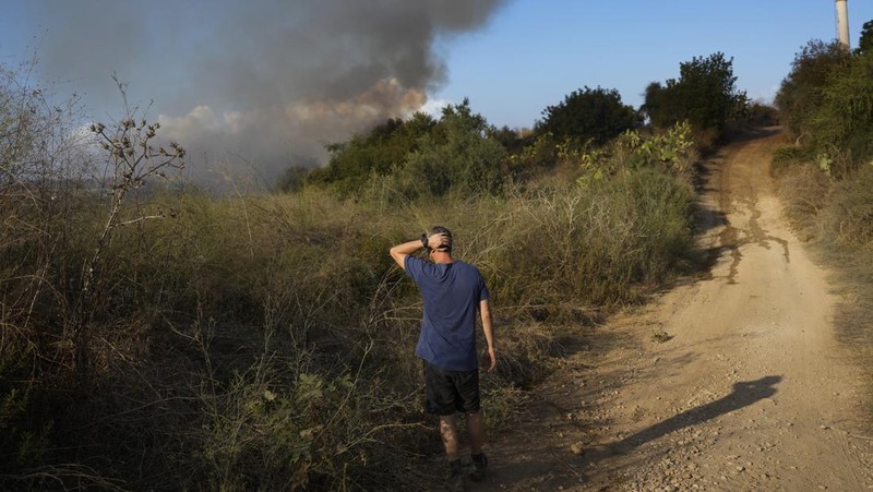 Seorang polisi memeriksa area kebakaran setelah militer menembakkan pencegat ke rudal dari Yaman yang jatuh di Israel tengah pada 15 September 2024. (REUTERS/Ronen Zvulun)