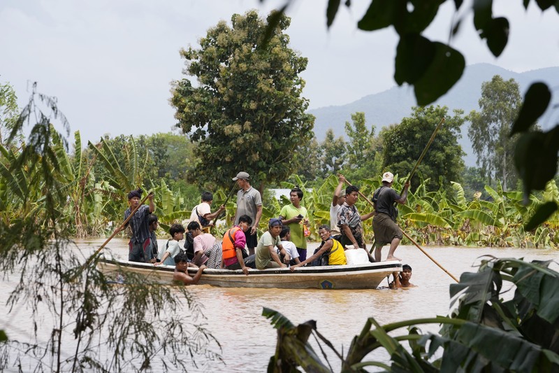 Warga dibantu melewati banjir oleh personel militer di Pyinmana di wilayah Naypyidaw, Myanmar, pada 13 September 2024, menyusul hujan lebat setelah Topan Yagi. (AFP/SAI AUNG MAIN)