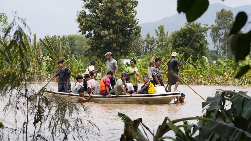 Warga dibantu melewati banjir oleh personel militer di Pyinmana di wilayah Naypyidaw, Myanmar, pada 13 September 2024, menyusul hujan lebat setelah Topan Yagi. (AFP/SAI AUNG MAIN)