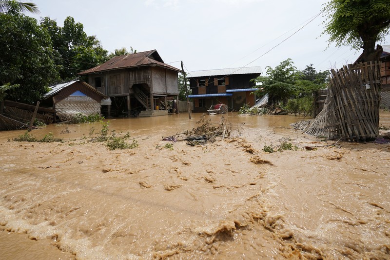 Warga dibantu melewati banjir oleh personel militer di Pyinmana di wilayah Naypyidaw, Myanmar, pada 13 September 2024, menyusul hujan lebat setelah Topan Yagi. (AFP/SAI AUNG MAIN)