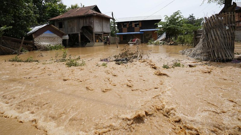 Warga dibantu melewati banjir oleh personel militer di Pyinmana di wilayah Naypyidaw, Myanmar, pada 13 September 2024, menyusul hujan lebat setelah Topan Yagi. (AFP/SAI AUNG MAIN)