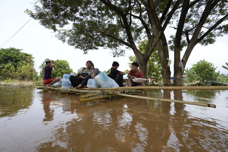 Warga dibantu melewati banjir oleh personel militer di Pyinmana di wilayah Naypyidaw, Myanmar, pada 13 September 2024, menyusul hujan lebat setelah Topan Yagi. (AFP/SAI AUNG MAIN)
