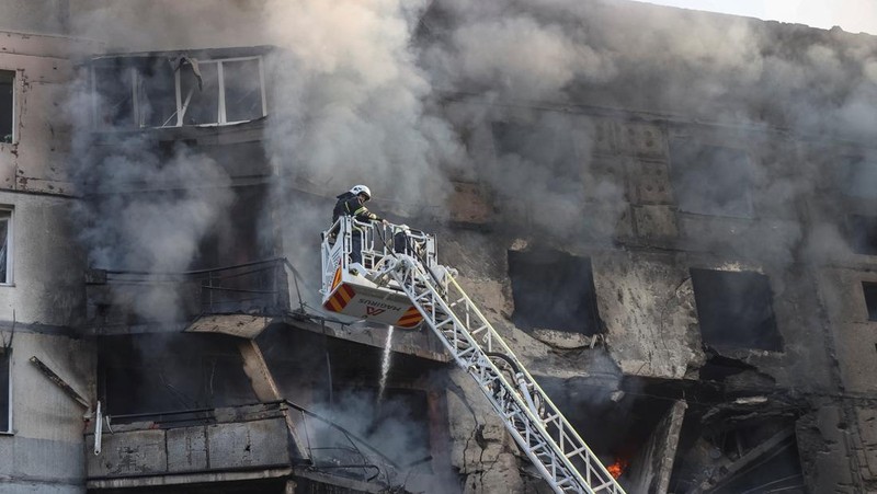 Para petugas SAR Ukraina sedang memadamkan api di gedung apartemen menyusul serangan rudal di Kharkiv di tengah invasi Rusia ke Ukraina, Minggu, 15 September 2024. (AP Photo/Andrii Marienko)