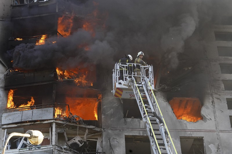 Para petugas SAR Ukraina sedang memadamkan api di gedung apartemen menyusul serangan rudal di Kharkiv di tengah invasi Rusia ke Ukraina, Minggu, 15 September 2024. (AP Photo/Andrii Marienko)