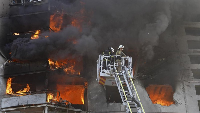 Para petugas SAR Ukraina sedang memadamkan api di gedung apartemen menyusul serangan rudal di Kharkiv di tengah invasi Rusia ke Ukraina, Minggu, 15 September 2024. (AP Photo/Andrii Marienko)