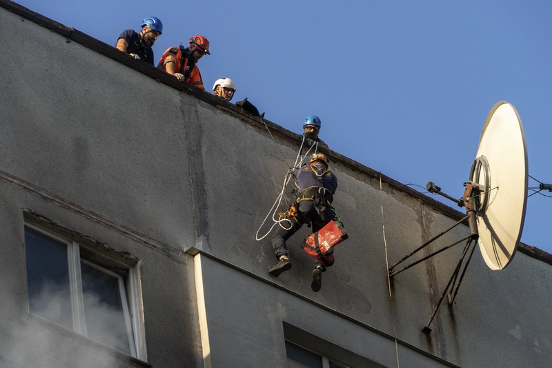 Para petugas SAR Ukraina sedang memadamkan api di gedung apartemen menyusul serangan rudal di Kharkiv di tengah invasi Rusia ke Ukraina, Minggu, 15 September 2024. (AP Photo/Andrii Marienko)