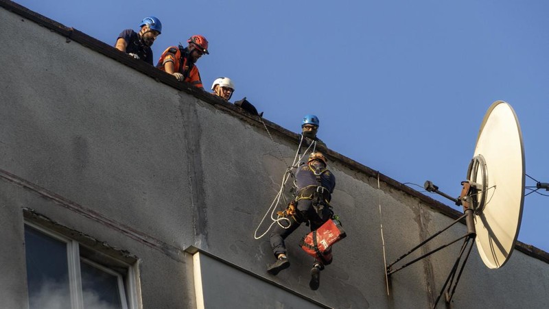 Para petugas SAR Ukraina sedang memadamkan api di gedung apartemen menyusul serangan rudal di Kharkiv di tengah invasi Rusia ke Ukraina, Minggu, 15 September 2024. (AP Photo/Andrii Marienko)