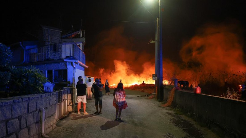 Seorang pria memegang ember selama kebakaran hutan di Nelas, Portugal, 16 September 2024. (REUTERS/Pedro Nunes)