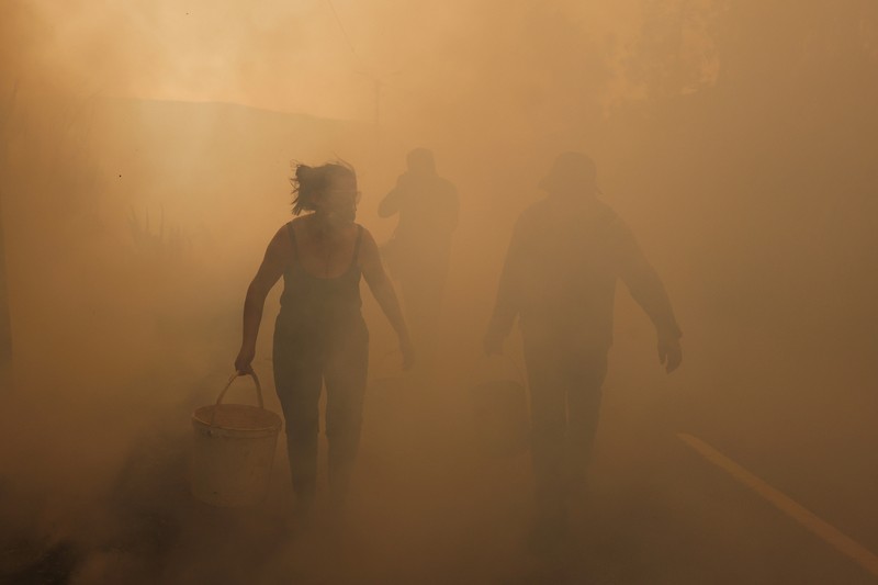 Orang-orang meninggalkan rumah mereka saat kebakaran hutan mendekat, di Veiga, Agueda, Portugal, 17 September 2024. Orang-orang meninggalkan rumah mereka saat kebakaran hutan mendekat, di Veiga, Agueda, Portugal, 17 September 2024. (REUTERS/Pedro Nunes)