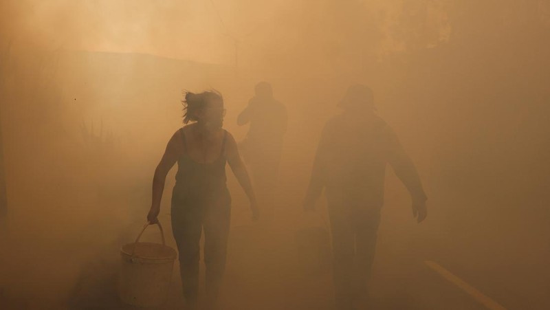 Orang-orang meninggalkan rumah mereka saat kebakaran hutan mendekat, di Veiga, Agueda, Portugal, 17 September 2024. (REUTERS/Pedro Nunes)