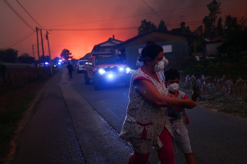 Orang-orang meninggalkan rumah mereka saat kebakaran hutan mendekat, di Veiga, Agueda, Portugal, 17 September 2024. Orang-orang meninggalkan rumah mereka saat kebakaran hutan mendekat, di Veiga, Agueda, Portugal, 17 September 2024. (REUTERS/Pedro Nunes)