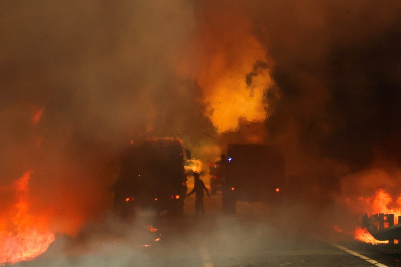 Orang-orang meninggalkan rumah mereka saat kebakaran hutan mendekat, di Veiga, Agueda, Portugal, 17 September 2024. (REUTERS/Pedro Nunes)