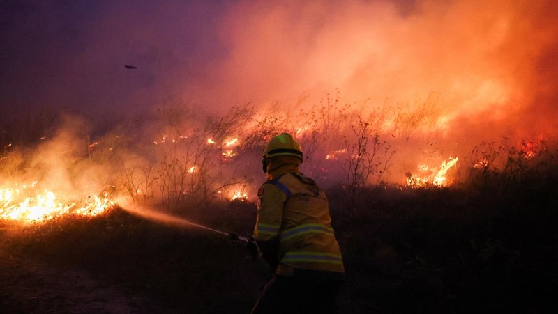 Orang-orang meninggalkan rumah mereka saat kebakaran hutan mendekat, di Veiga, Agueda, Portugal, 17 September 2024. (REUTERS/Pedro Nunes)