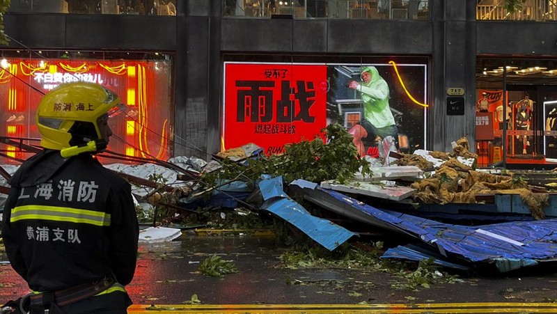 Dalam foto yang dirilis oleh Kantor Berita Xinhua ini, para pekerja membersihkan pohon tumbang di sepanjang jalan setelah Topan Bebinca di Shanghai, Tiongkok, Senin, 16 September 2024. (Chen Haoming/Xinhua via AP)