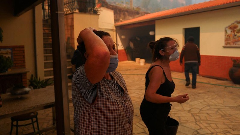 Orang-orang meninggalkan rumah mereka saat kebakaran hutan mendekat, di Veiga, Agueda, Portugal, 17 September 2024. (REUTERS/Pedro Nunes)