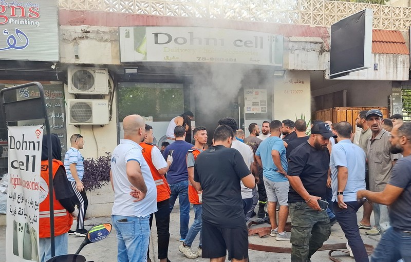 Orang-orang berkumpul saat asap mengepul dari sebuah toko keliling di Sidon, Lebanon, 18 September 2024. Orang-orang berkumpul saat asap mengepul dari sebuah toko keliling di Sidon, Lebanon, 18 September 2024. (REUTERS/Hassan Hankir)