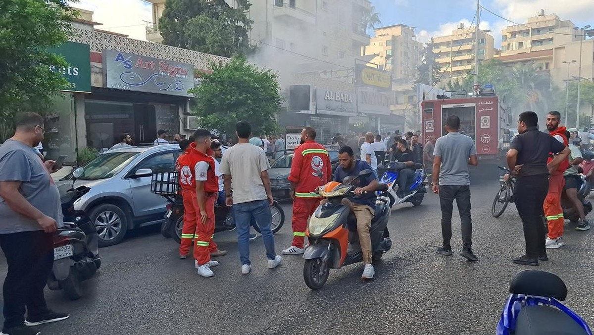 orang-orang-berkumpul-saat-asap-mengepul-dari-sebuah-toko-keliling-di-sidon-lebanon-18-september-2024_169 Ledakan Massal Lebanon Langgar Hukum Internasional? Ini Kata Ahli