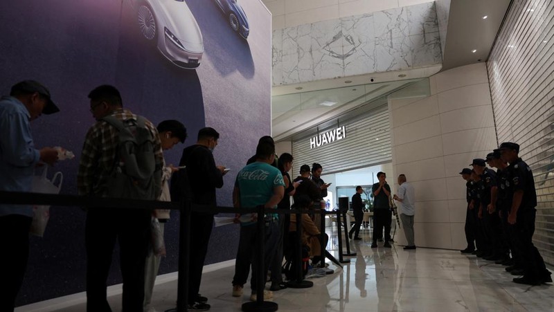 Orang-orang mengantre untuk melihat ponsel utama Huawei pintar lipat tiga Huawei Mate XT mulai dijual di Beijing, Tiongkok, 20 September 2024. (REUTERS/Wang Jiawei)