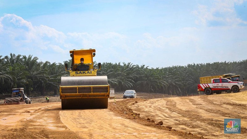 Beberapa pekerja mengoperasikan alat berat untuk meratakan tanah di proyek Tol Betung - Tempino - Jambi seksi 1A di Banyuasin, Palembang, Jumat (20/9/2024). (CNBC Indonesia/Tias Budiarto)