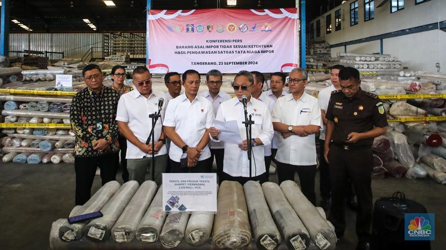 Petugas kepolisian memeriksa barang tekstil dan produk tekstil impor ilegal di Kawasan Industri Jatake, Kota Tangerang, Banten, Senin (23/9/2024). (CNBC Indonesia/Faisal Rahman)