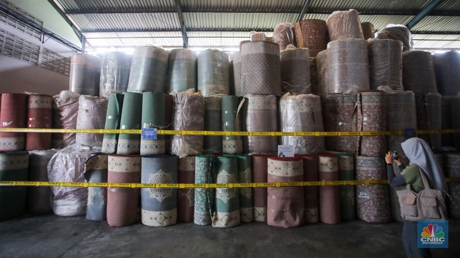 Petugas kepolisian memeriksa barang tekstil dan produk tekstil impor ilegal di Kawasan Industri Jatake, Kota Tangerang, Banten, Senin (23/9/2024). (CNBC Indonesia/Faisal Rahman)
