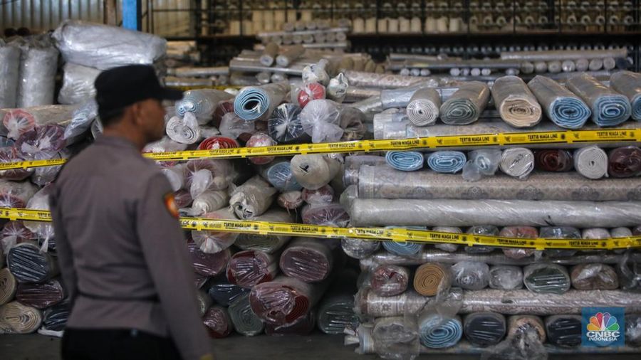 Petugas kepolisian memeriksa barang tekstil dan produk tekstil impor ilegal di Kawasan Industri Jatake, Kota Tangerang, Banten, Senin (23/9/2024). (CNBC Indonesia/Faisal Rahman)