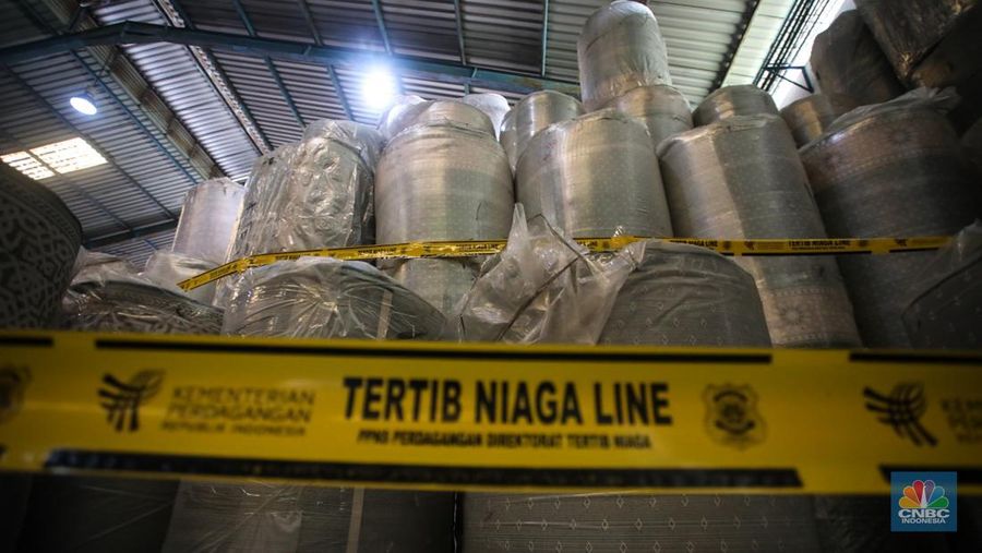 Petugas kepolisian memeriksa barang tekstil dan produk tekstil impor ilegal di Kawasan Industri Jatake, Kota Tangerang, Banten, Senin (23/9/2024). (վ/Faisal Rahman)