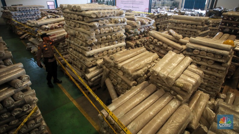 Petugas kepolisian memeriksa barang tekstil dan produk tekstil impor ilegal di Kawasan Industri Jatake, Kota Tangerang, Banten, Senin (23/9/2024). (CNBC Indonesia/Faisal Rahman)