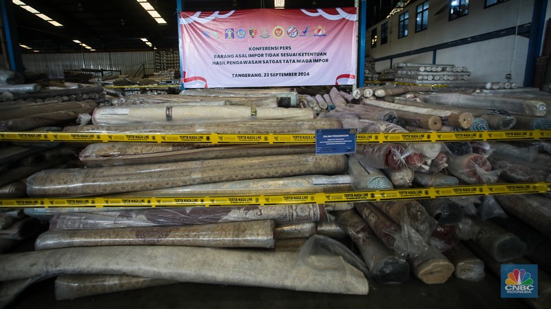 Petugas kepolisian memeriksa barang tekstil dan produk tekstil impor ilegal di Kawasan Industri Jatake, Kota Tangerang, Banten, Senin (23/9/2024). (CNBC Indonesia/Faisal Rahman)