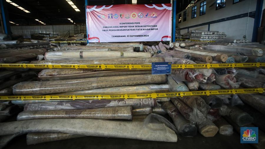 Petugas kepolisian memeriksa barang tekstil dan produk tekstil impor ilegal di Kawasan Industri Jatake, Kota Tangerang, Banten, Senin (23/9/2024). (CNBC Indonesia/Faisal Rahman)