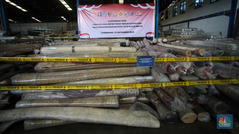 Petugas kepolisian memeriksa barang tekstil dan produk tekstil impor ilegal di Kawasan Industri Jatake, Kota Tangerang, Banten, Senin (23/9/2024). (CNBC Indonesia/Faisal Rahman)