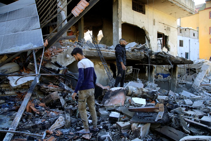 Orang-orang berdiri di atas reruntuhan bangunan yang rusak, di desa Akbiyeh di selatan Lebanon, di tengah permusuhan lintas perbatasan antara Hizbullah dan pasukan Israel, Lebanon, 24 September 2024. Orang-orang berdiri di atas reruntuhan bangunan yang rusak, di desa Akbiyeh di selatan Lebanon, di tengah permusuhan lintas perbatasan antara Hizbullah dan pasukan Israel, Lebanon, 24 September 2024. (REUTERS/Stringer)